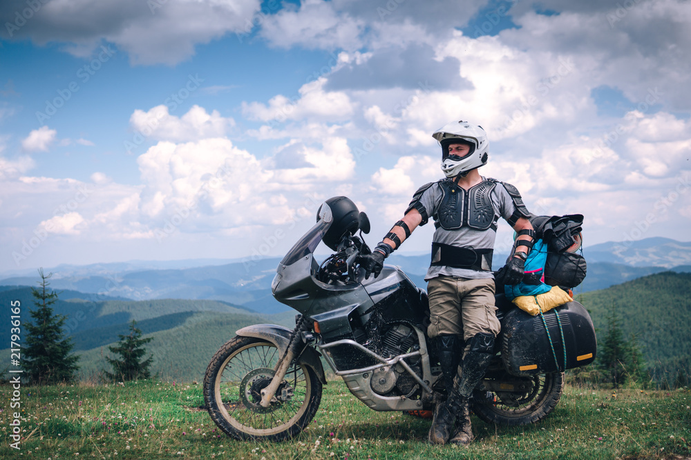 Fototapeta premium Motorcyclist man and Adventure Motorbike on the top of the mountain. Motorcycle trip. off road Traveling, Lifestyle Travel vacations sport outdoor concept.