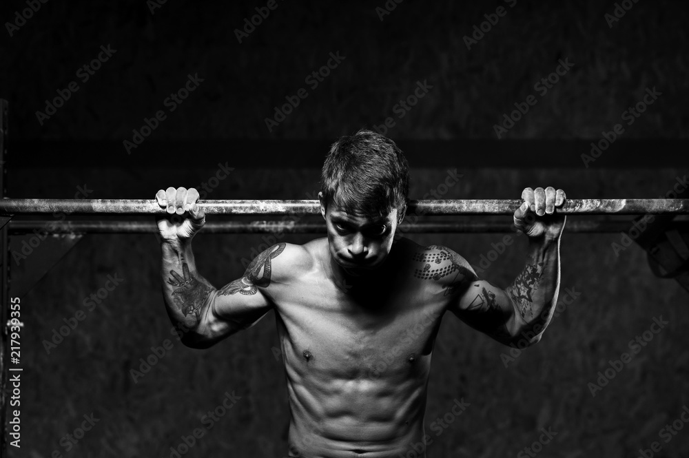 Muscular male athlete doing pull up exercise on horizontal bar. sports, fitness concept. Muscular male athlete doing pull up exercise on horizontal bar. sports, fitness concept.