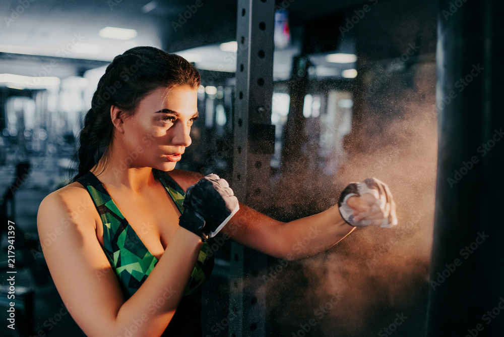 Sexy fighter girl in gym ready to work with boxing bag. Fitness model. Sort concept.