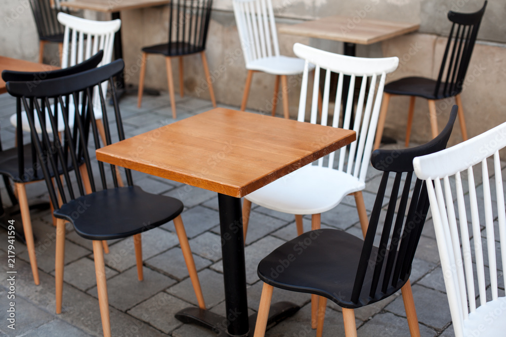 View of empty outdoor terrace cafe outdoor with retro wooden chairs and table in sunny summer day View of empty outdoor terrace cafe outdoor with retro wooden chairs and table in sunny summer day