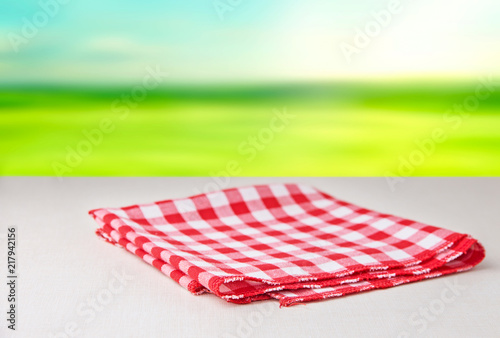
Red tablecloth in a cage folded in two isolated on a white background