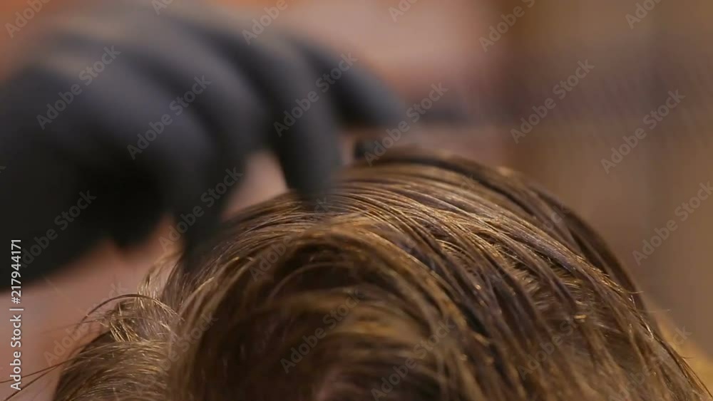 Master cuts hair and beard of men in the barbershop, hairdresser makes hairstyle for a young man