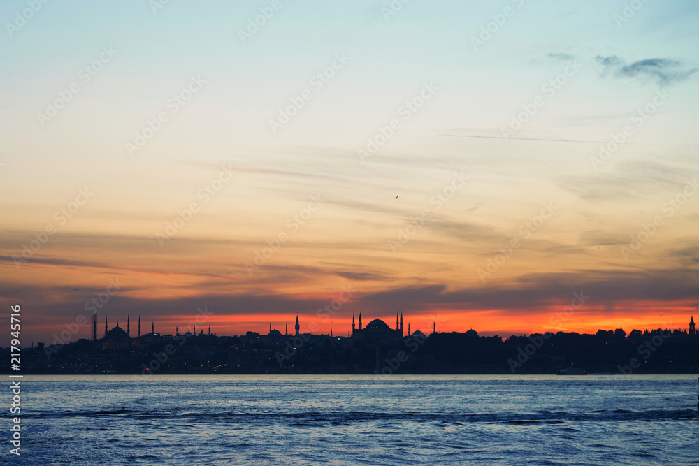Dramatic sunset silhouettes of historic buildings in Istanbul.