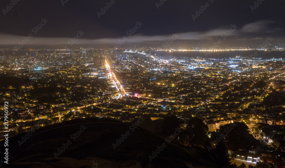 Night view of San Francisco Bay Area with Bay Bridge and Market Street illuminated