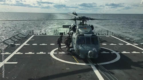 Special forces getting onboard navy helicopter at sea. photo