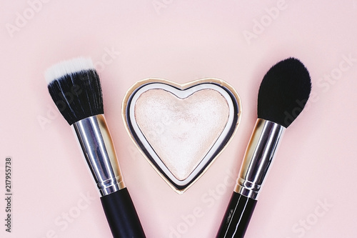 Glitter and makeup brush on a pink background photo