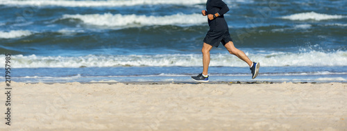 Athletic Fitness ManRunning on the Beach. Male Runner Jogging. Outdoor Workout. Fitness Concept. photo