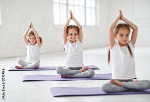 children girls doing yoga and gymnastics in gym