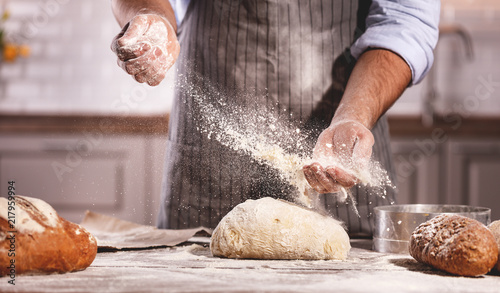 Photographie hands of baker's male knead dough