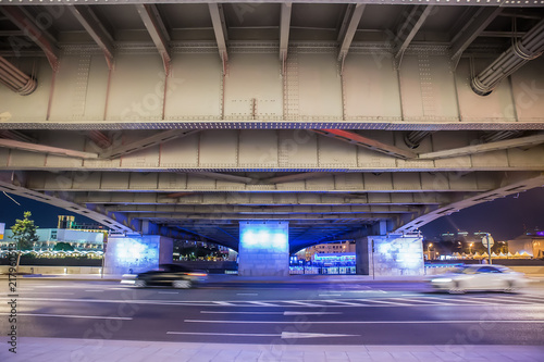 Cars move at night under the bridge in the city © Yuri Bizgaimer
