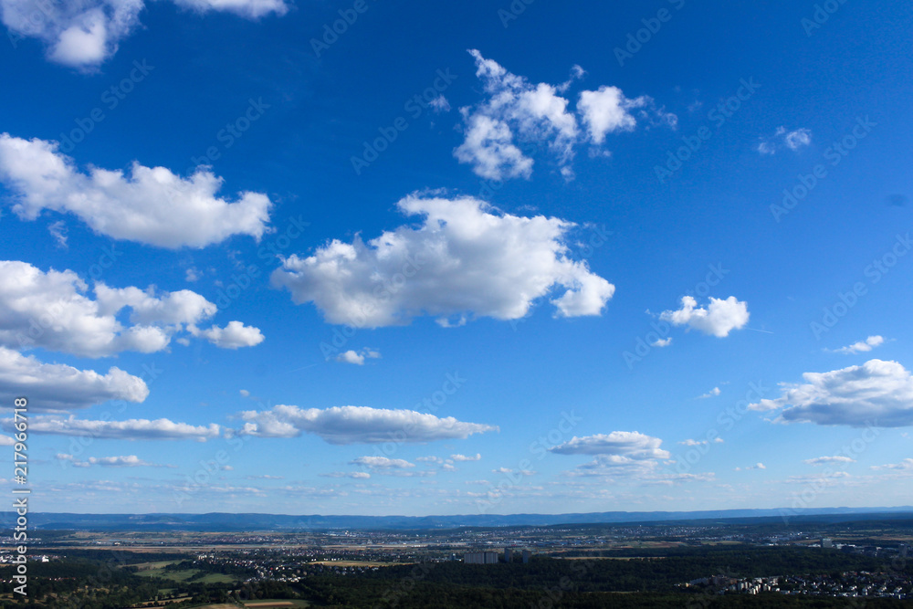 Amazing Landscape view on the beautiful forests, alpine mountains and idyllic fields of South Germany with a blue sky before sunset with clouds