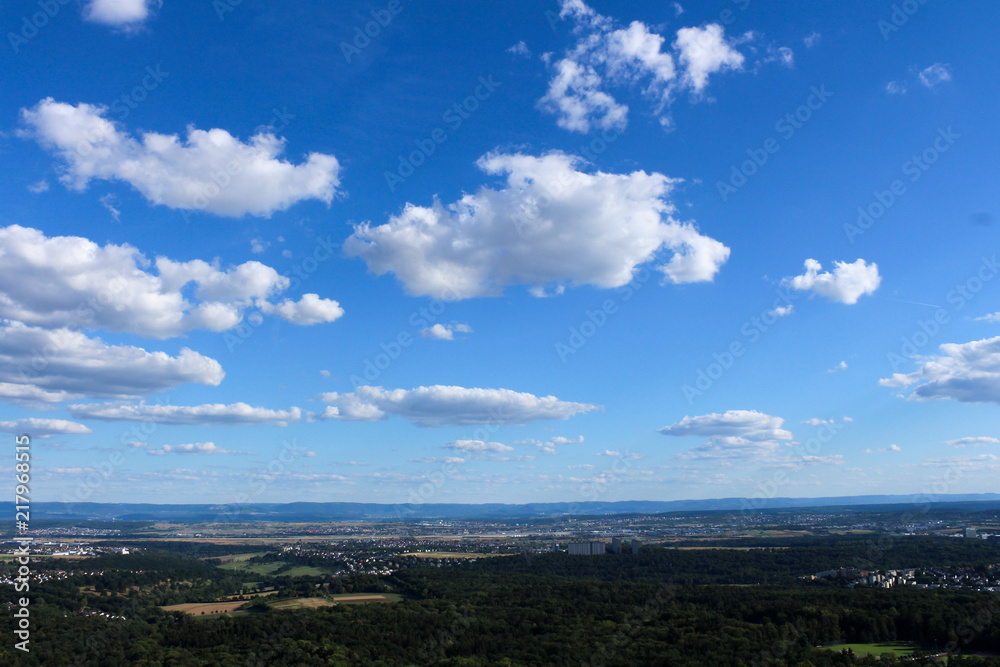 Amazing Landscape view on the beautiful forests, alpine mountains and idyllic fields of South Germany with a blue sky before sunset with clouds