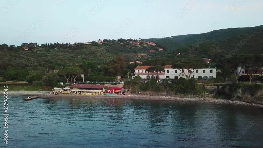 Aerial view, at dusk, of a lovelyTuscany bay with a little restaurant on the beach Aerial view, at dusk, of a lovelyTuscany bay with a little restaurant on the beach