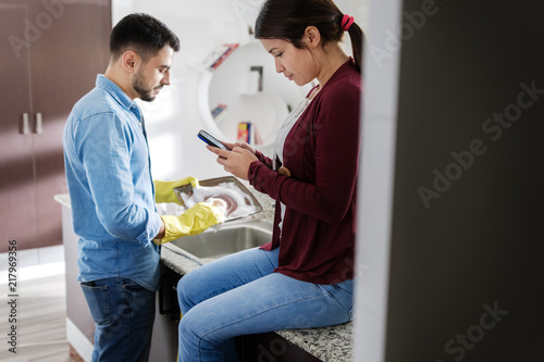 Man And Woman Doing Home Chores In Kitchen
