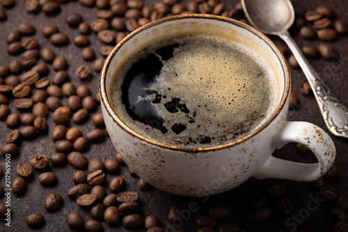 Close-up of a Cup of black coffee and coffee beans on a dark background