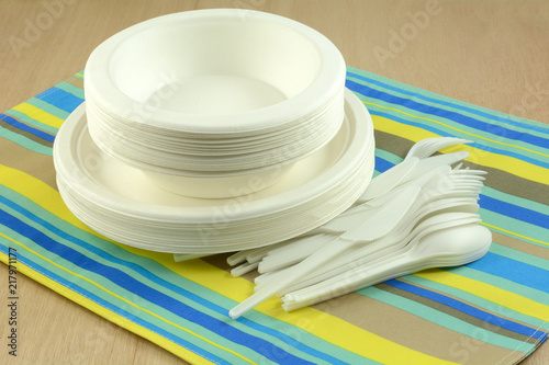 White eco-friendly disposable compostable plates bowls and cutlery on place mat 