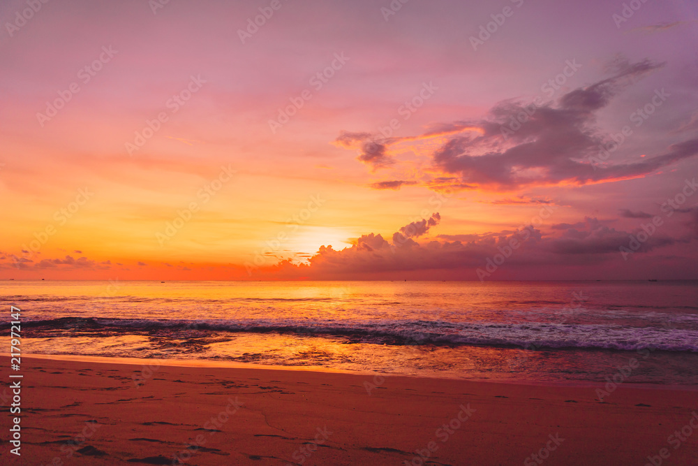 Colorful bright sunset or sunrise at sandy beach with ocean in California