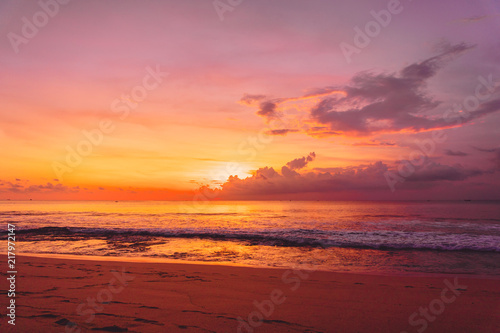 Colorful bright sunset or sunrise at sandy beach with ocean in California