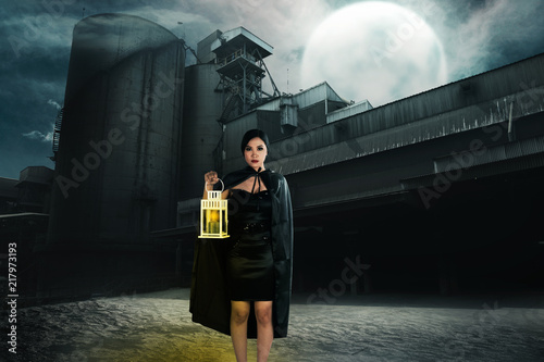 Beautiful asian witch with lantern on the abandoned place