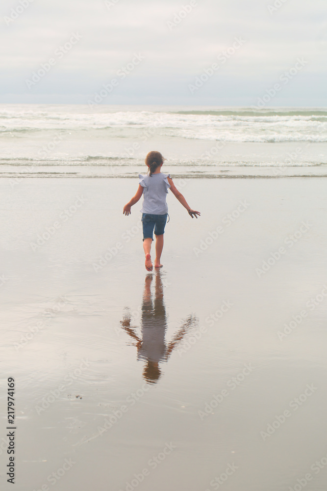 Small, Cute, 6 years Girl, Brown hair, playing in the water, running, Pacific Ocean, Oregon coast, family vacation time, reflection in the water