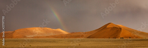 Rainbow shines over a sand dune in the desert