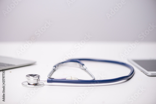 Workplace of doctor with laptop and stethoscope and notebook on white table top view shot.