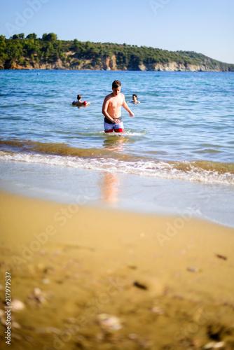 Young boy in swimsuit walking through the sea © qunica.com