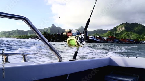 Leaving the Rarotonga harbour to head out game fishing, with game rod and reel in foreground photo