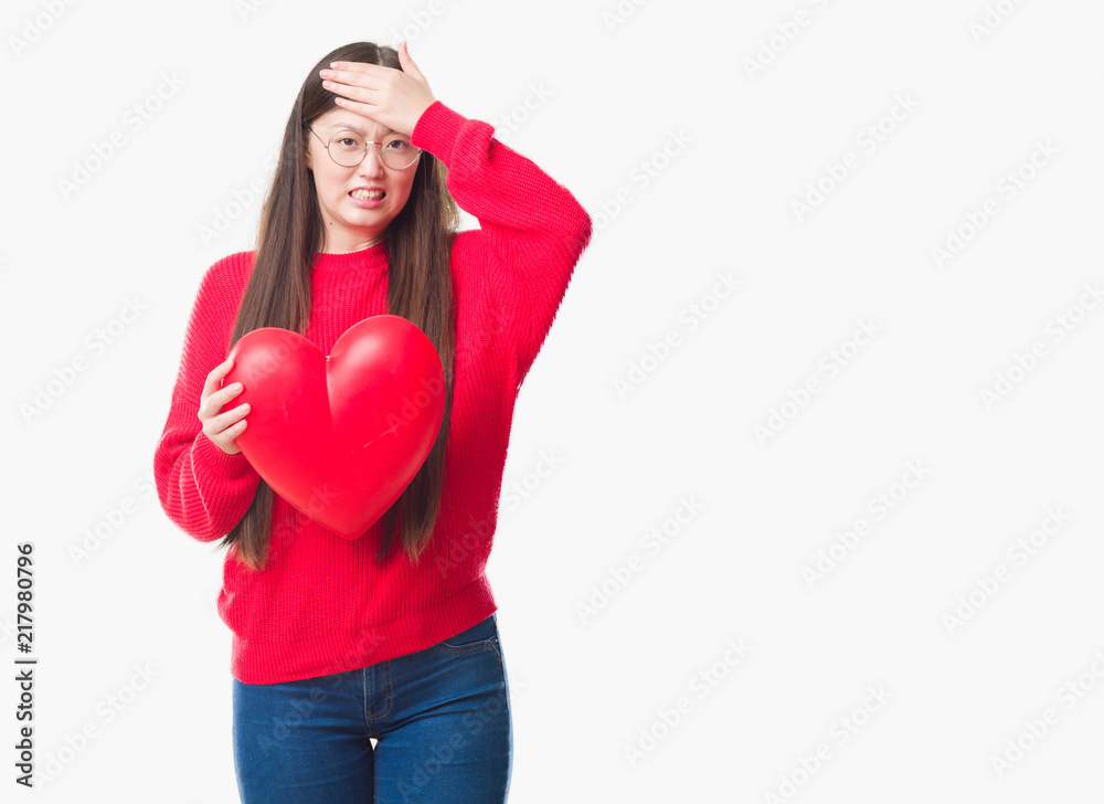 Young Chinese woman wearing graduate uniform red heart stressed with hand on head, shocked with shame and surprise face, angry and frustrated. Fear and upset for mistake. Young Chinese woman wearing graduate uniform red heart stressed with hand on head, shocked with shame and surprise face, angry and frustrated. Fear and upset for mistake.