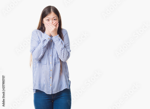 Young Chinese woman over isolated background shocked covering mouth with hands for mistake. Secret concept. © Krakenimages.com