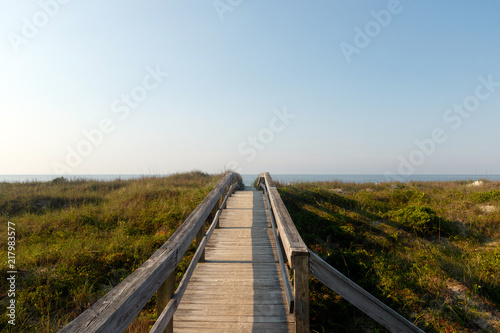 Long wooden boardwalk through the green dune grass to the Atlantic Ocean, Sunset Beach, North Carolina
