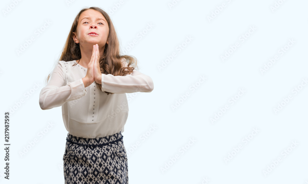 Brunette hispanic girl begging and praying with hands together with hope expression on face very emotional and worried. Asking for forgiveness. Religion concept.