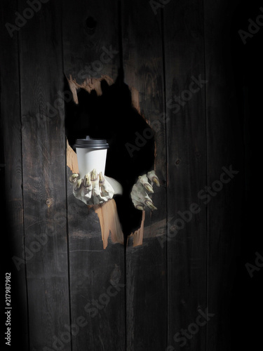 Zombie hand through hole cracked in rustic wood.Halloween theme