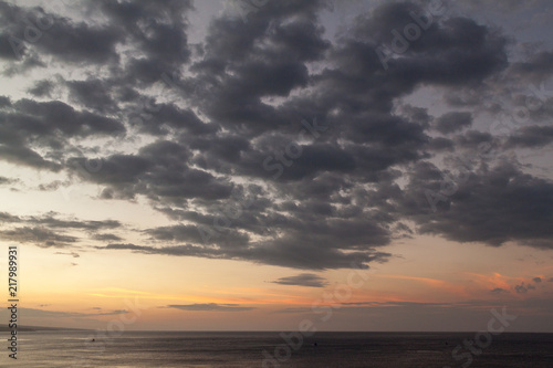 Large grey sunset clouds over the sea