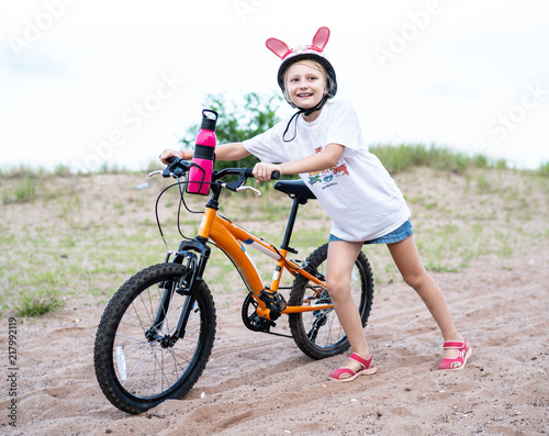 Girl with bicucle outdoors photo