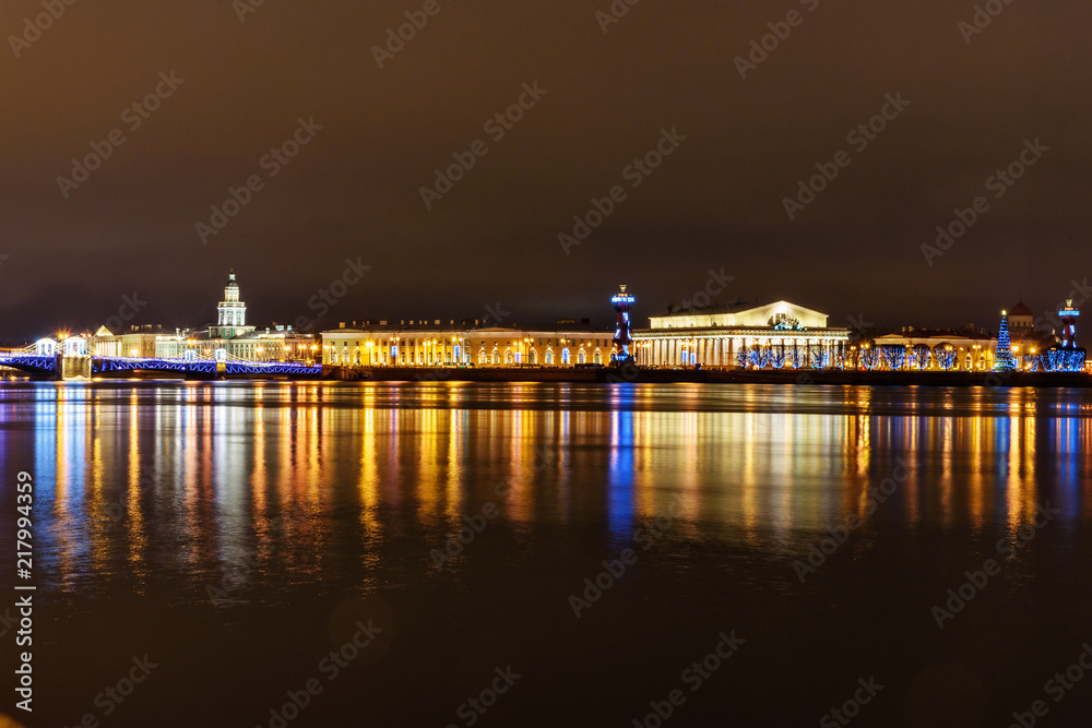 Palace Bridge and Vasilyevsky island Spit Strelka with Rostral columns at night. Saint Petersburg, Russia