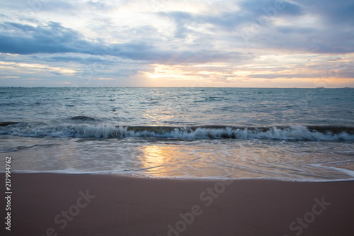 Fototapeta Naklejka Na Ścianę i Meble -  Sand beach with sea waves in the sunset.