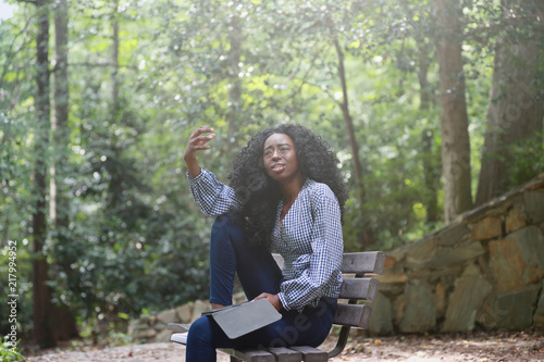 Black woman reading emotive book in park