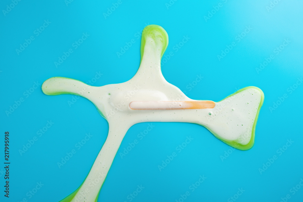 yellow popsicle in a melting process on blue background yellow popsicle in a melting process on blue background