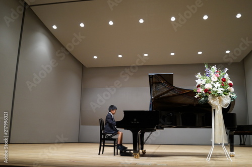 ピアノの発表会　ピアニスト　ピアノ　ステージ　発表会　スポットライト　花