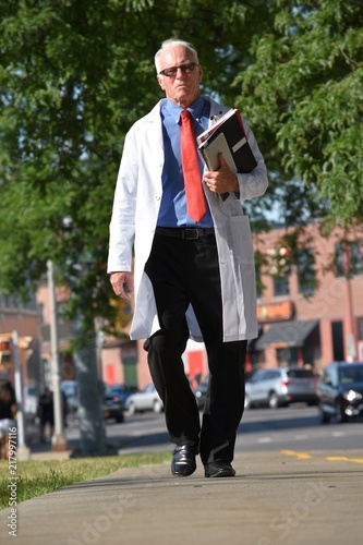 Serious Handsome Senior Person Wearing Lab Coat Walking © dtiberio