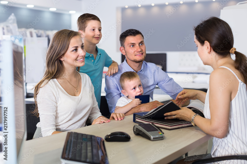 Obraz premium cheerful family of four choosing fabric for upholstery mattress in salon
