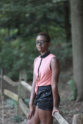 Trendy black woman in shorts and glasses