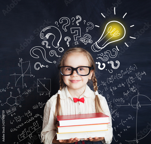 Elementary school student girl with proud expression showing his ideas over his head. Kid holding books photo