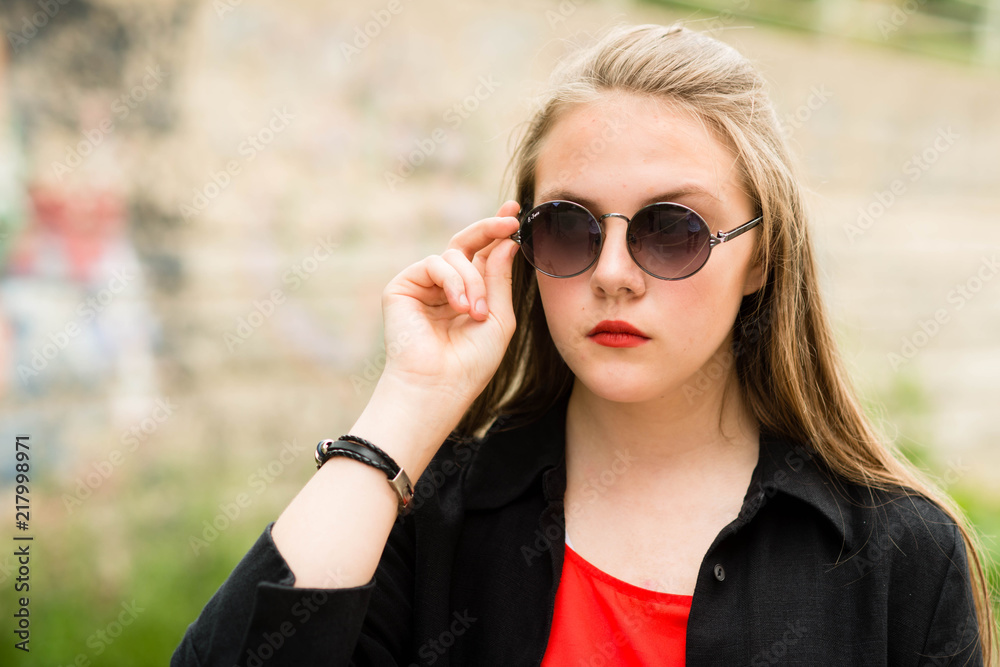 beautiful girl with long hair in sunglasses with bag in long dark clothes beautiful girl with long hair in sunglasses with bag in long dark clothes