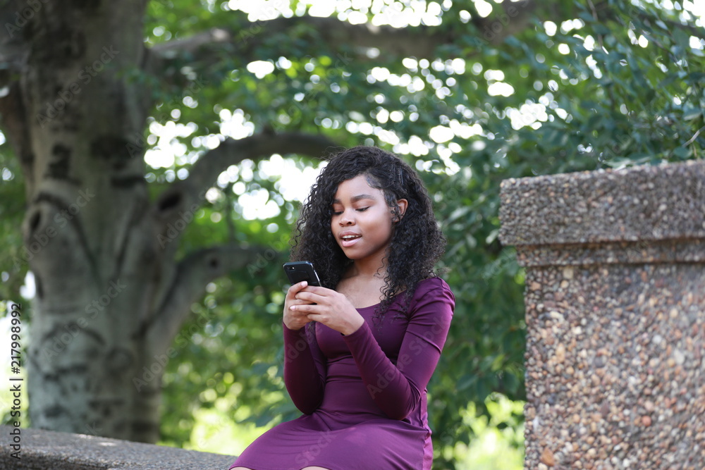 Black female using smartphone in park