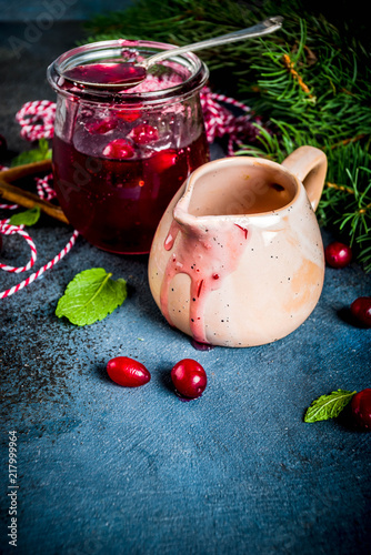 Fototapeta Naklejka Na Ścianę i Meble -  Traditional Thanksgiving Christmas food, homemade cranberry sauce, with mint and fresh berries, dark blue table, with  fir tree and saucer, copy space for text