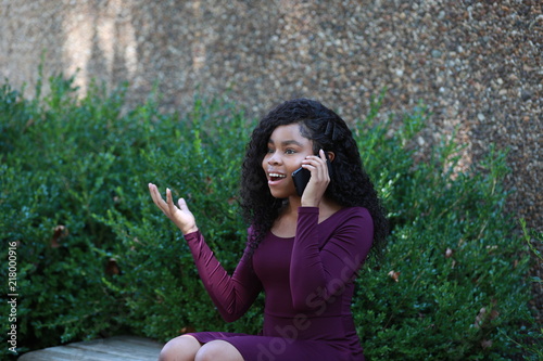 Excited black female speaking on smartphone © kosim