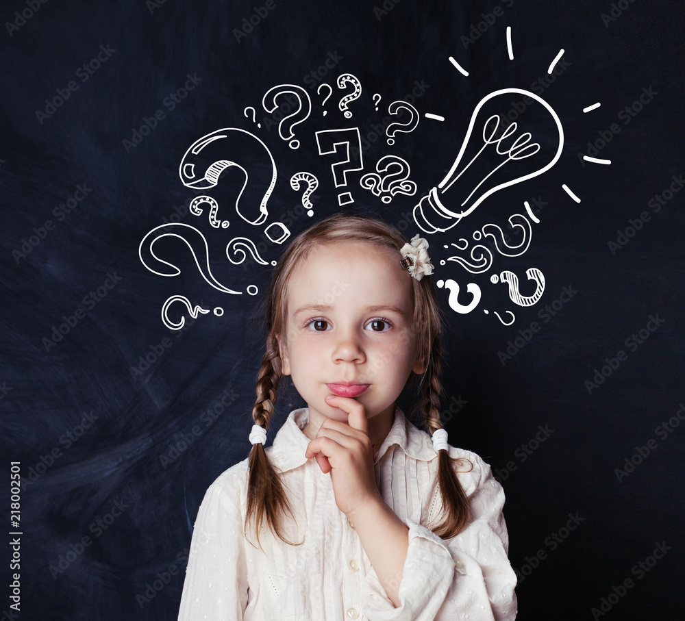 Smart child schoolgirl with lightbulb and chalk question marks on school blackboard background. Idea concept