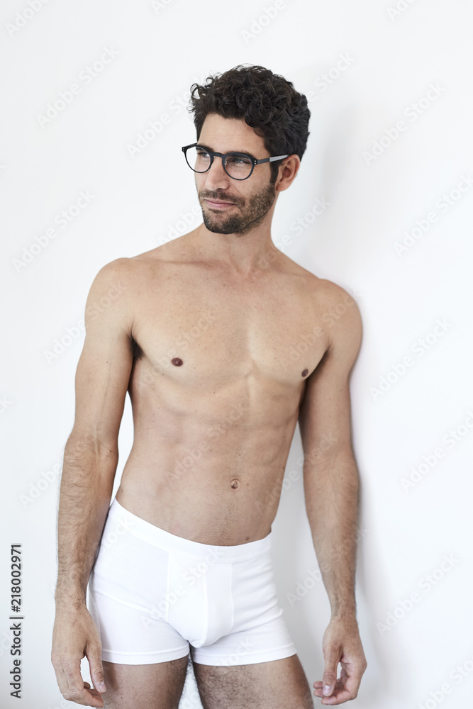 Handsome guy in glasses and underwear, looking away Handsome guy in glasses and underwear, looking away